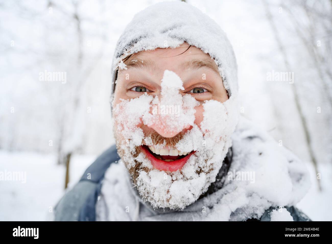 Homme heureux avec un visage couvert de neige au parc d'hiver Banque D'Images