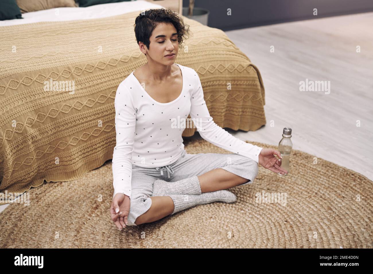 Pratiquez la pleine conscience. une jeune femme attirante méditant sur son plancher de chambre à la maison. Banque D'Images