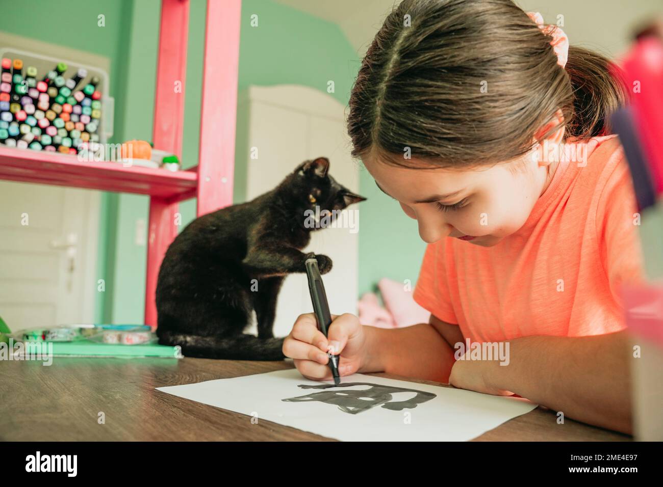 Fille dessin photo de chat sur papier à la maison Banque D'Images