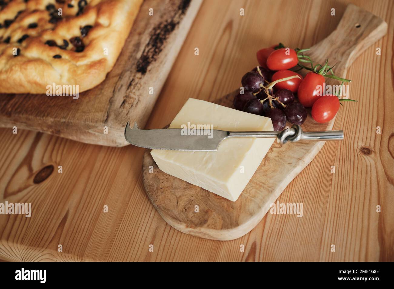 Fromage aux tomates et raisins avec focaccia sur la table de cuisine Banque D'Images