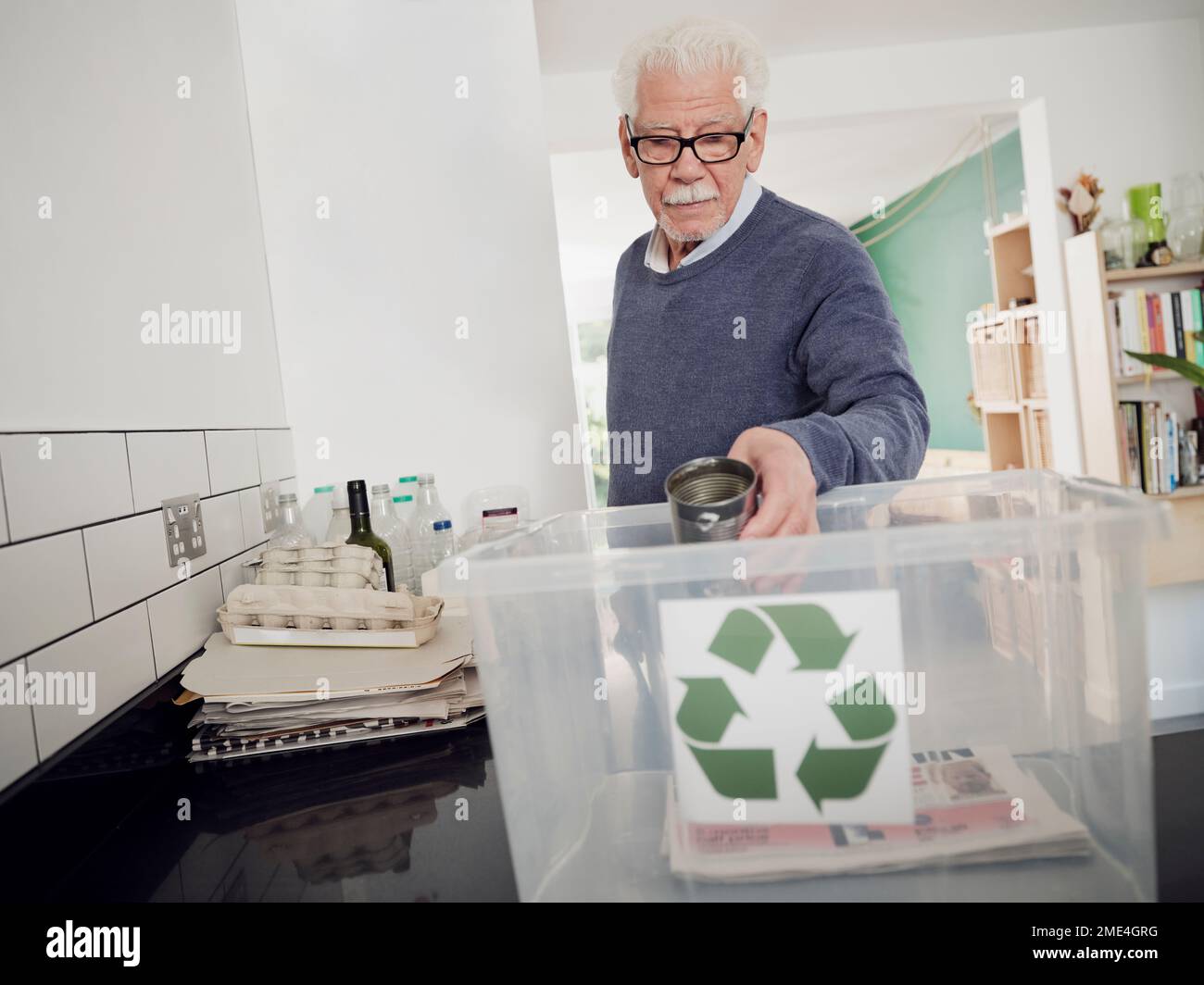 Homme senior plaçant les déchets séparés dans la boîte de recyclage Banque D'Images