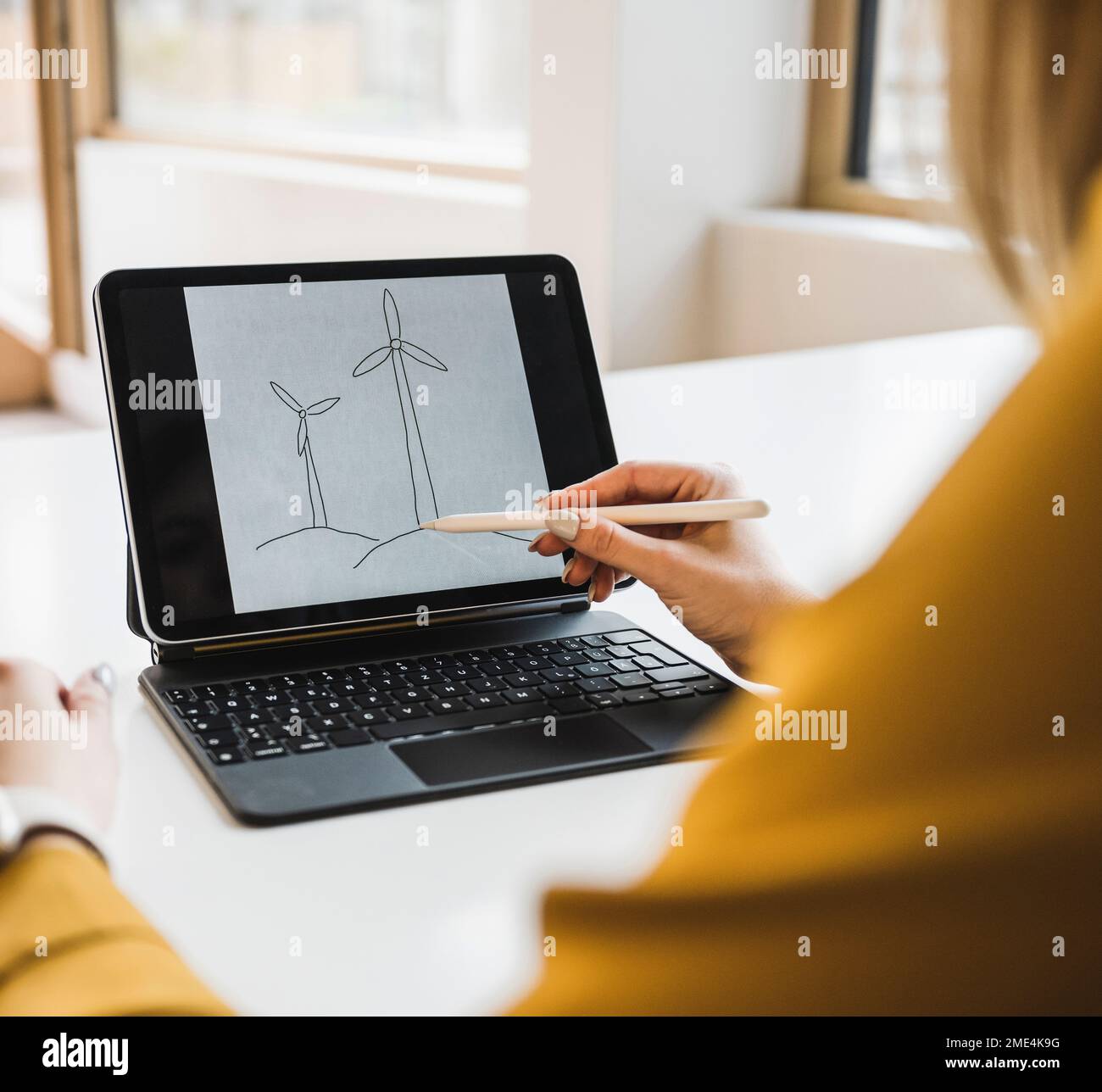 Femme d'affaires avec stylo numérique dessin éolienne sur tablette PC Banque D'Images