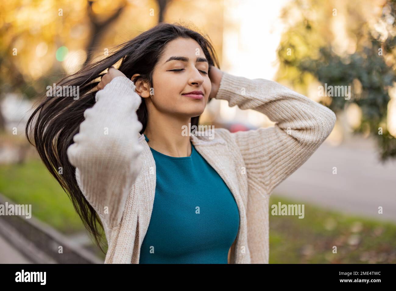 Bonne femme avec les yeux fermés debout au parc Banque D'Images