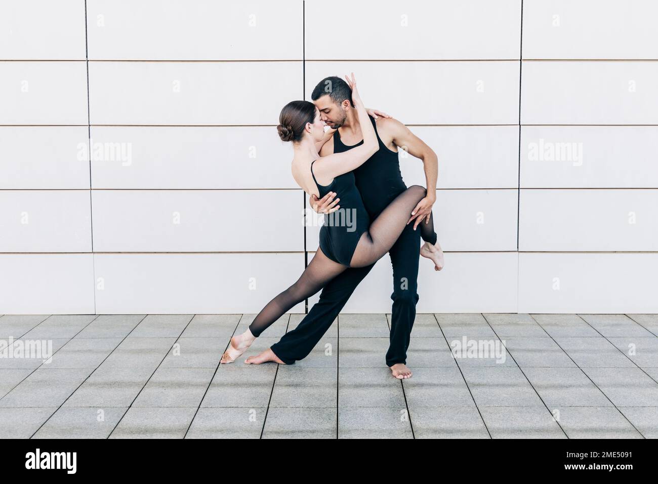 Couple effectuant une danse de ballet devant le mur Banque D'Images