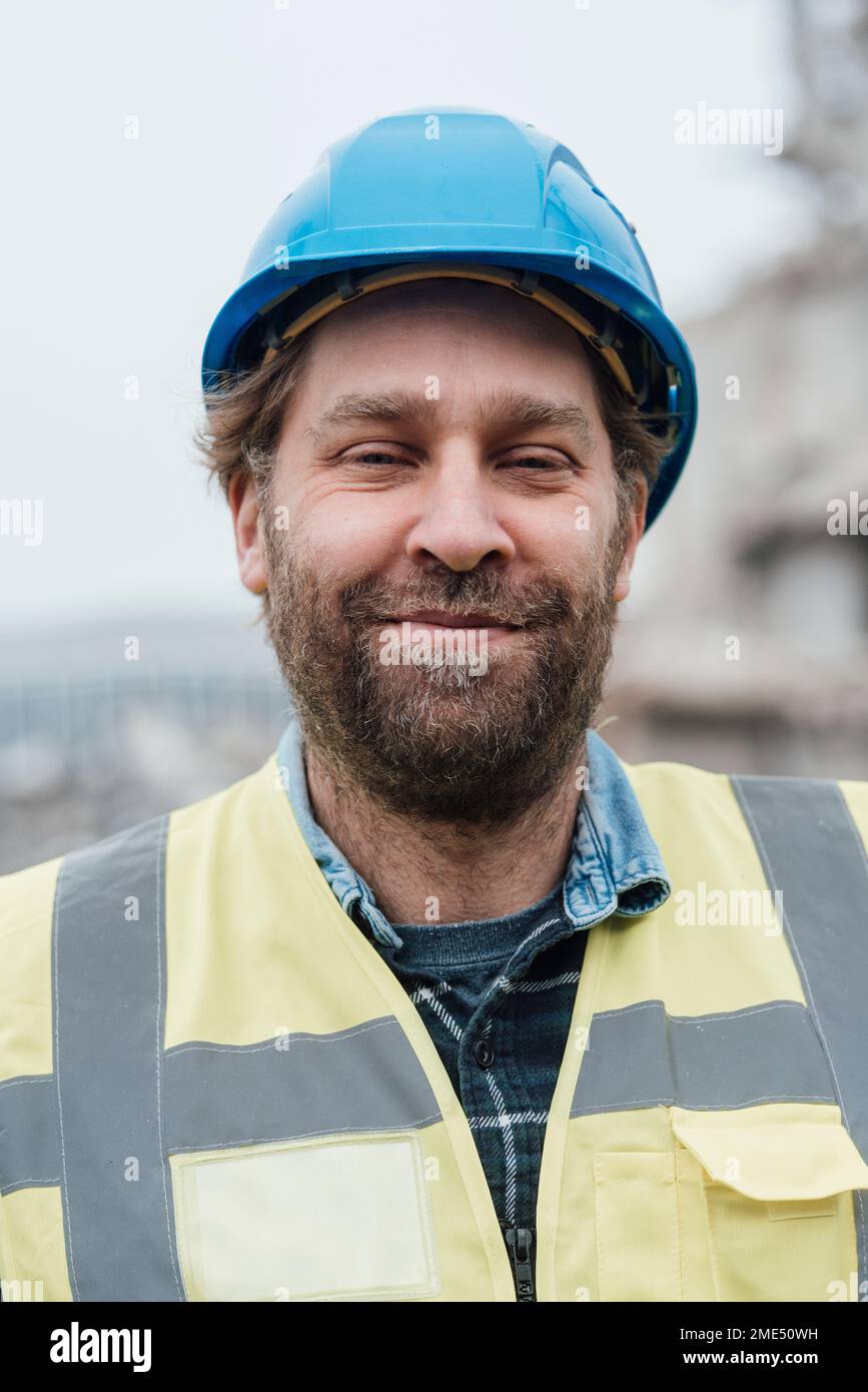 Travailleur de la construction souriant portant un casque de sécurité Banque D'Images