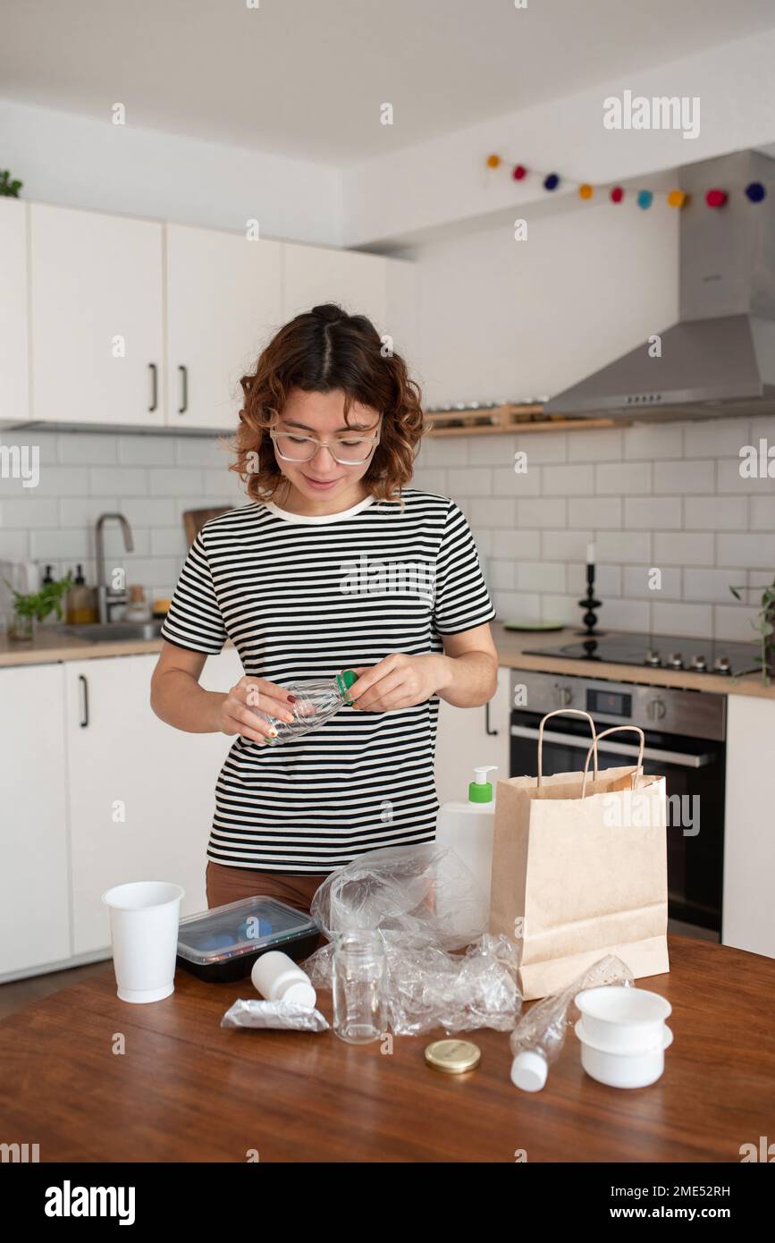 Femme recyclant les déchets de plastique dans la cuisine à la maison Banque D'Images