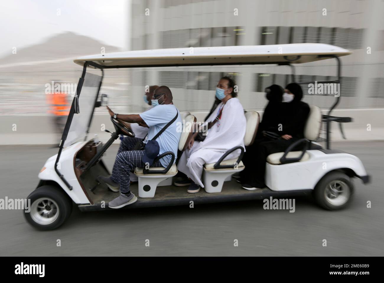 Muslim pilgrims ride a golf cart after they cast a symbolic stoning of the devil ritual during the Hajj pilgrimage in Mina, near Saudi Arabia's holy city of Mecca, Saudi Arabia, Tuesday, July 20, 2021. The coronavirus has taken its toll on the hajj for a second year running. What once drew some 2.5 million Muslims from all walks of life from across the globe, the hajj pilgrimage is now almost unrecognizable in scale. (AP Photo/Amr Nabil) Banque D'Images
