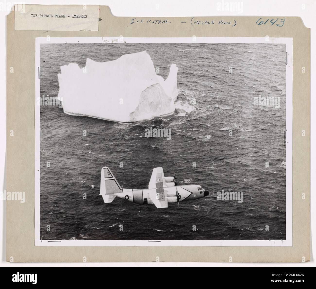 Surveillance des glaces plans de vues massive Iceberg. A ÉTATS-UNIS L'avion de patrouille sur glace Hercules HC-130-B de la Garde côtière d'Argentia, à Terre-Neuve, suit un iceberg massif observé le long des Grands bancs au large de Terre-Neuve à travers les puissantes jumelles d'un observateur assis à une fenêtre latérale de l'avion. L'observateur, un officier de la garde côtière spécialement formé à la détermination de la taille, de la direction et de la vitesse des bergs, est entré dans le calcul de l'observation et de la distance pris par Radar dans son journal. Après le vol, son entrée est contrôlée par rapport à la position de Loran obtenue par le navigateur pendant le vol. À partir de ces données, le locati Banque D'Images