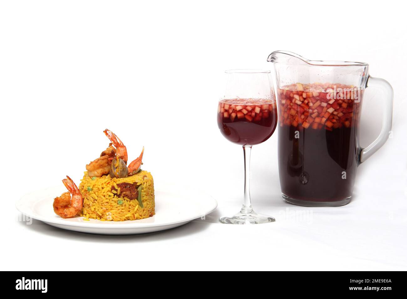 Riz traditionnel paella de Valence Espagne, fait avec des coquillages safran, des crevettes et des légumes servis sur une assiette blanche accompagnée de vin rouge et un Banque D'Images