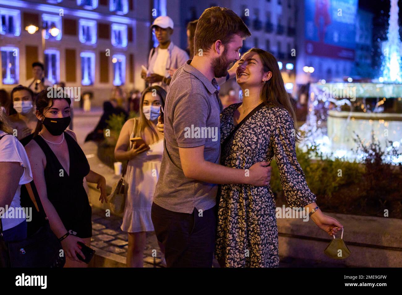 A couple celebrate the first day without face masks in the outdoors at Sol square in Madrid, Spain, early Saturday, June 26, 2021. Almost a year after face masks became mandatory indoors and outdoors, people from Saturday will no longer be required to wear them outside as long as they can stay at least 1.5 meters (5 feet) apart. (AP Photo/Manu Fernandez) Banque D'Images