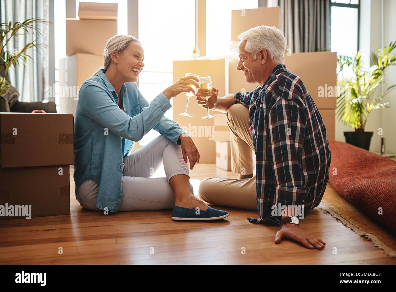 Heres à Happy Times en tant que propriétaires. un couple heureux et mûr qui toasque avec du vin le jour de la journée. Banque D'Images