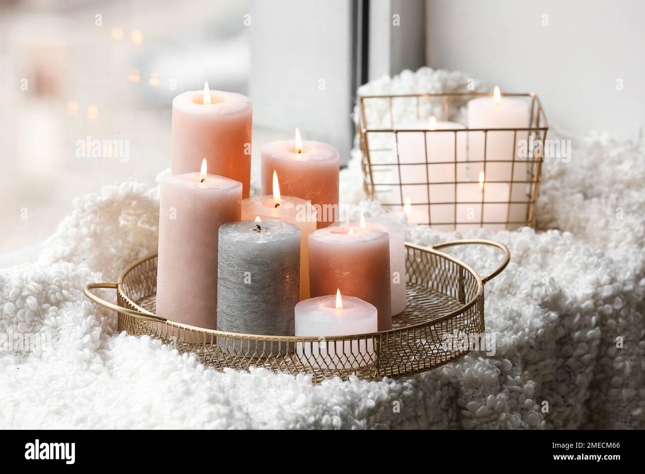 Plateau doré et panier avec bougies allumées sur couverture en laine au  seuil de la fenêtre Photo Stock - Alamy