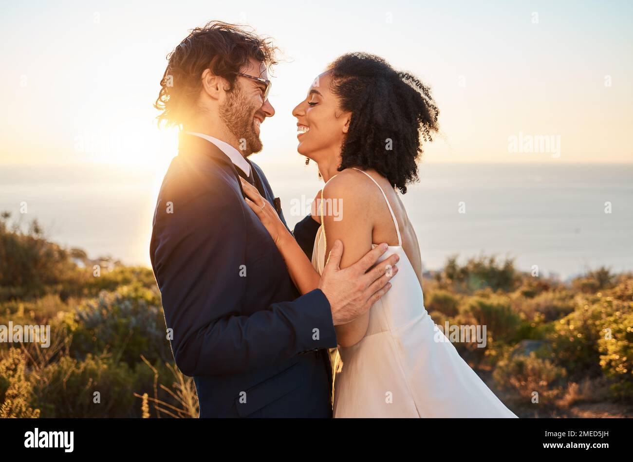 Amour, heureux et mariage avec couple dans la nature pour la célébration, le bonheur et le romantisme. Coucher de soleil, câlin et affectueux avec l'homme et la femme en étreinte à Banque D'Images