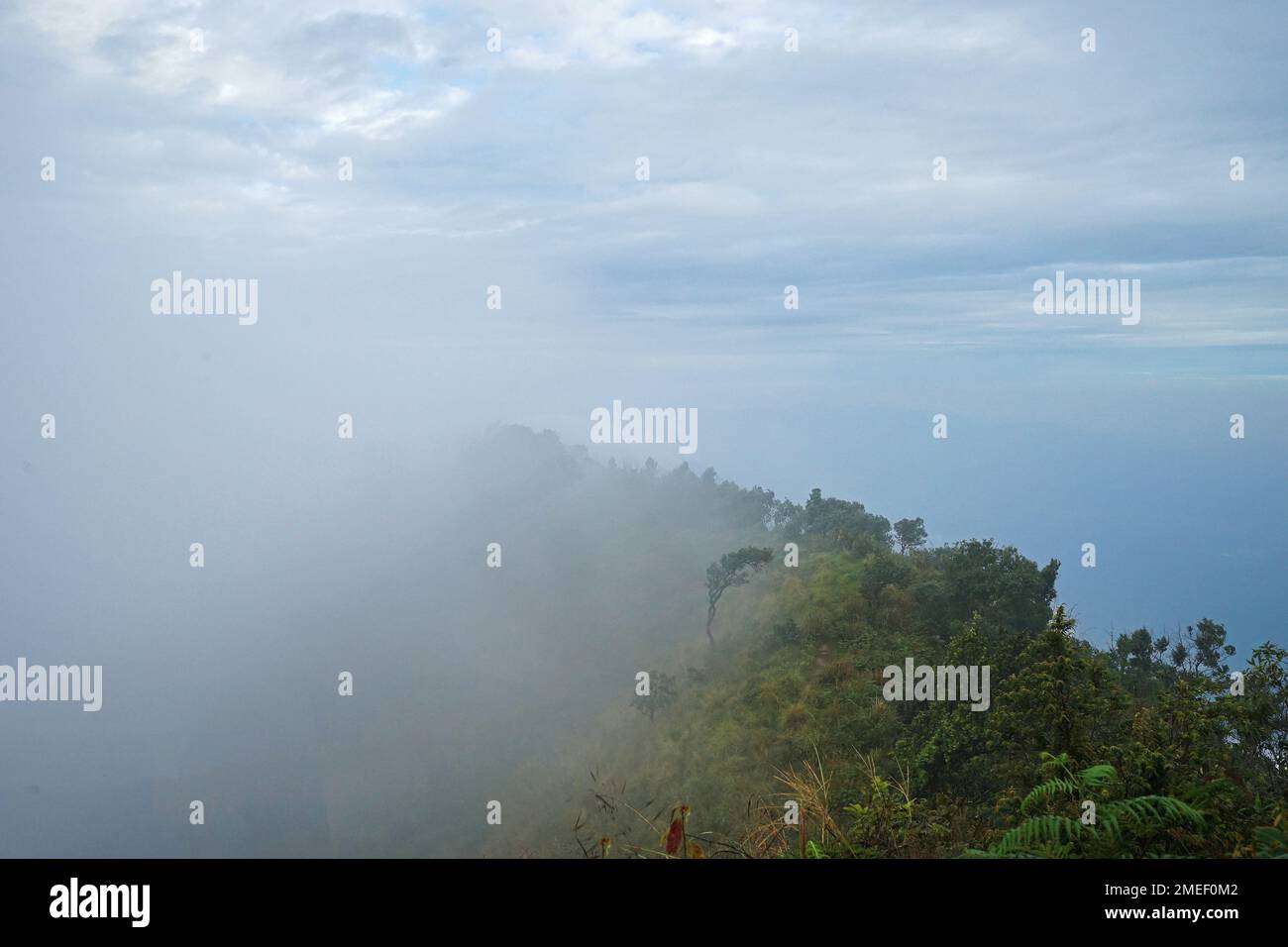 Vue sur le paysage naturel au sommet de la chaîne de montagnes verdoyantes et ciel bleu nuageux Banque D'Images