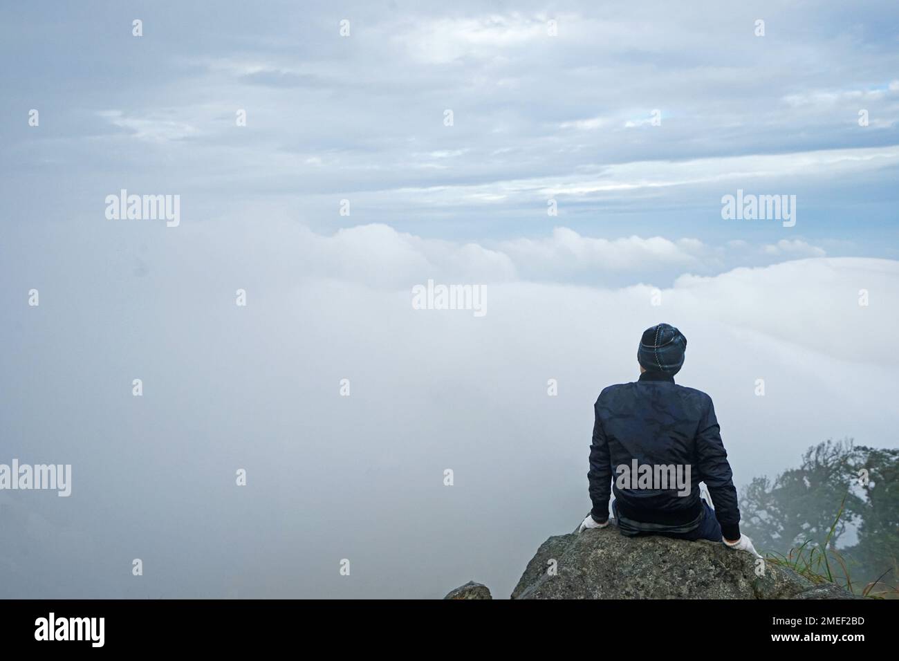 Un homme qui monte sur la crête de montagne verte avec un ciel bleu nuageux Banque D'Images