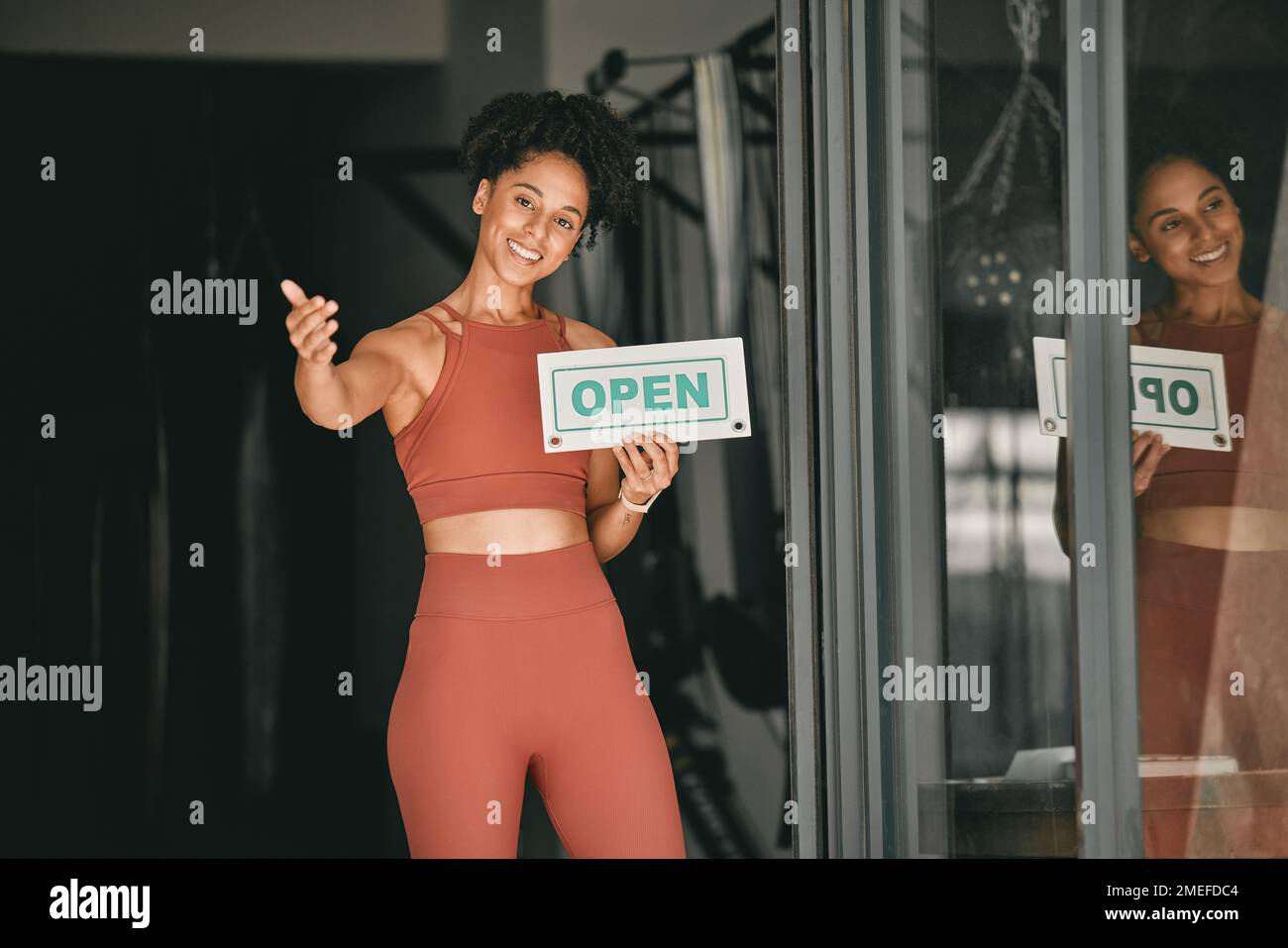 Femme noire, bienvenue et propriétaire de la salle de gym avec panneau ouvert pour la forme physique ou l'entraînement. Portrait de femme afro-américaine, entrepreneur sportif et Banque D'Images