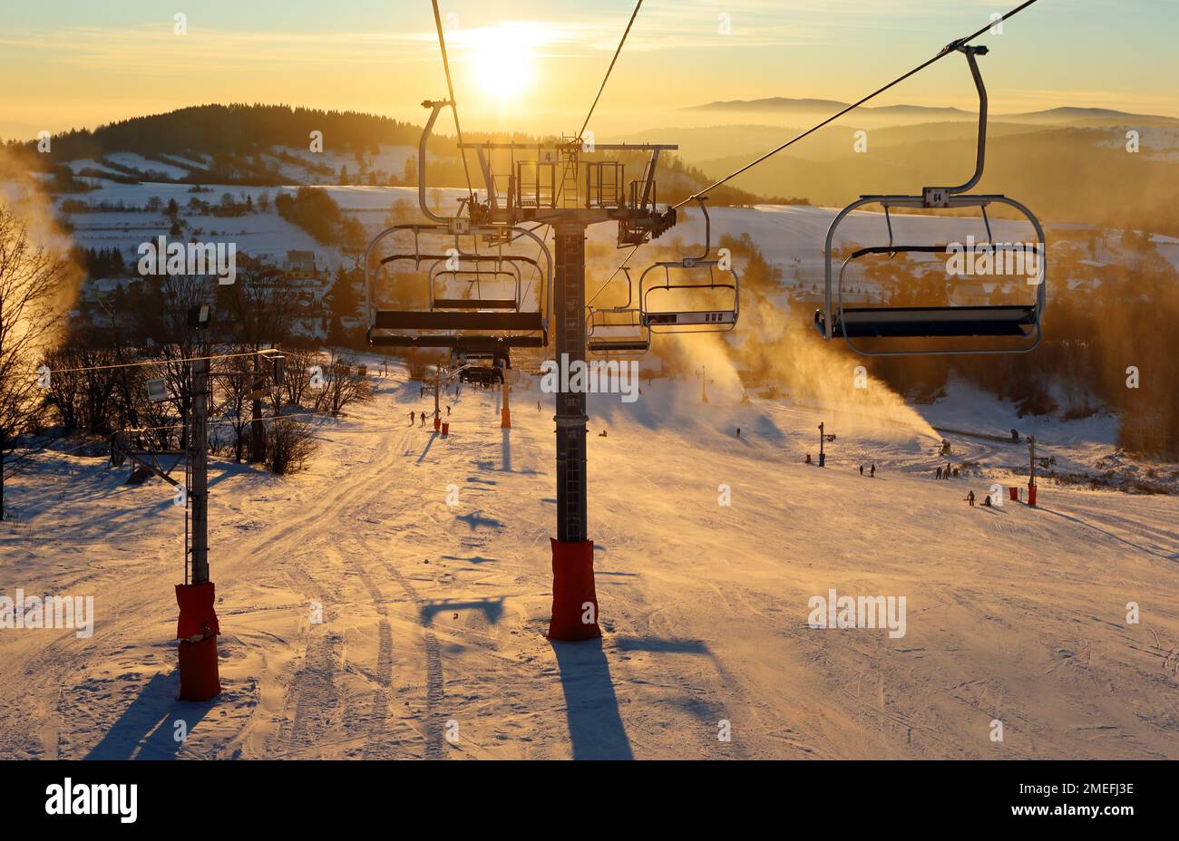 Station de ski, skieurs sur les remontées mécaniques, pins blancs à l'aube ou au coucher du soleil rose, Krahule Slovaquie Banque D'Images