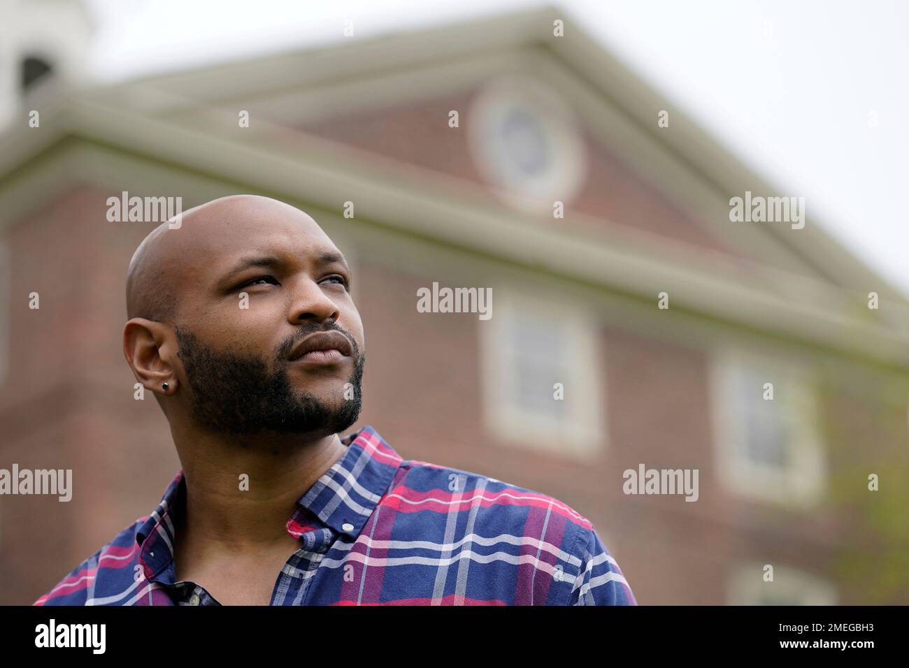 Brown University graduate Jason Carroll, a Maryland native whose ancestors were slaves in the Carolinas, stands for a portrait on the Brown campus in Providence, R.I., on Tuesday, May 4, 2021, near University Hall, background, that was constructed in part using slave labor. “There’s real trauma and pain here,” says Carroll. “This shouldn’t just be an academic question. There are real families that have been burdened and harmed by this — and probably still are.” (AP Photo/Steven Senne) Banque D'Images