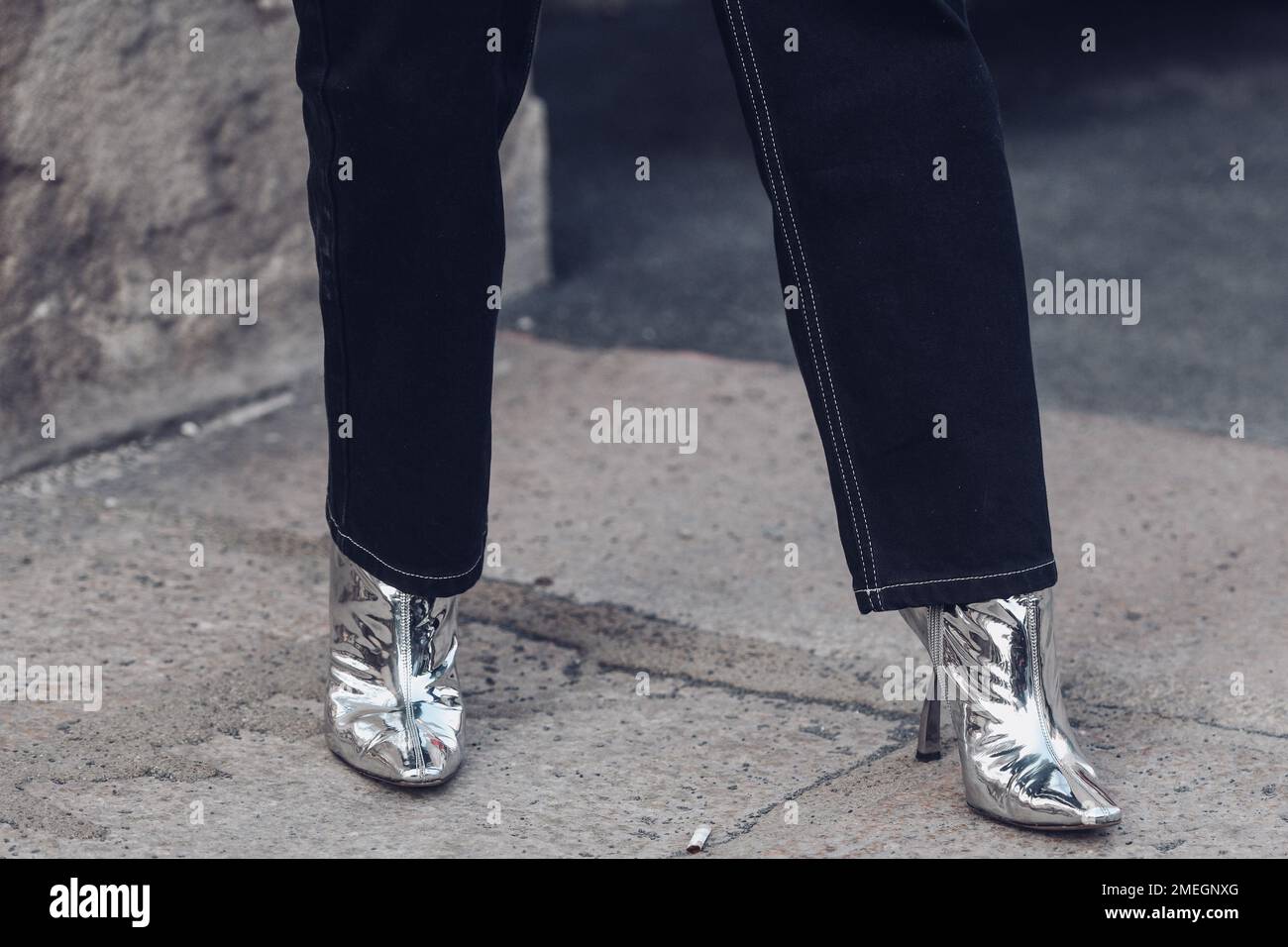 Milan, Italie - 24 février 2022: Femme portant un Jean foncé et des bottes en argent à pointe pailletée. Banque D'Images