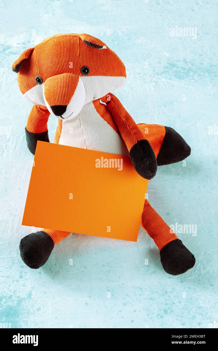 Maquette pour une carte orange avec un renard jouet. Modèle de carte de vœux ou d'invitation avec espace de copie Banque D'Images