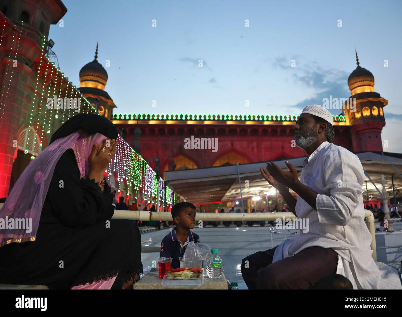 An Indian Muslim family offer prayers before breaking their day-long fast during Ramadan at Mecca Masjid in Hyderabad, India, Thursday, May 6, 2021. Islam's holiest month of Ramadan is a period of intense prayer, dawn-to-dusk fasting and nightly feasts. (AP Photo /Mahesh Kumar A.) Banque D'Images