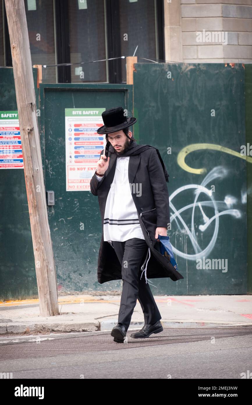 Un juif orthodoxe marchant à Brooklyn. Son tzitzit ou tallis katan, franges ritualistes mandatées dans l'ancien testament. Banque D'Images
