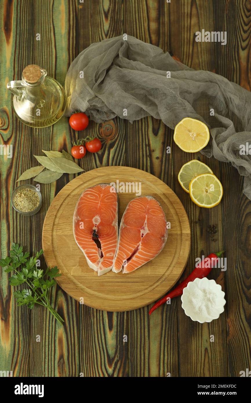 Steak de saumon frais avec ingrédients sur fond de bois sombre Banque D'Images