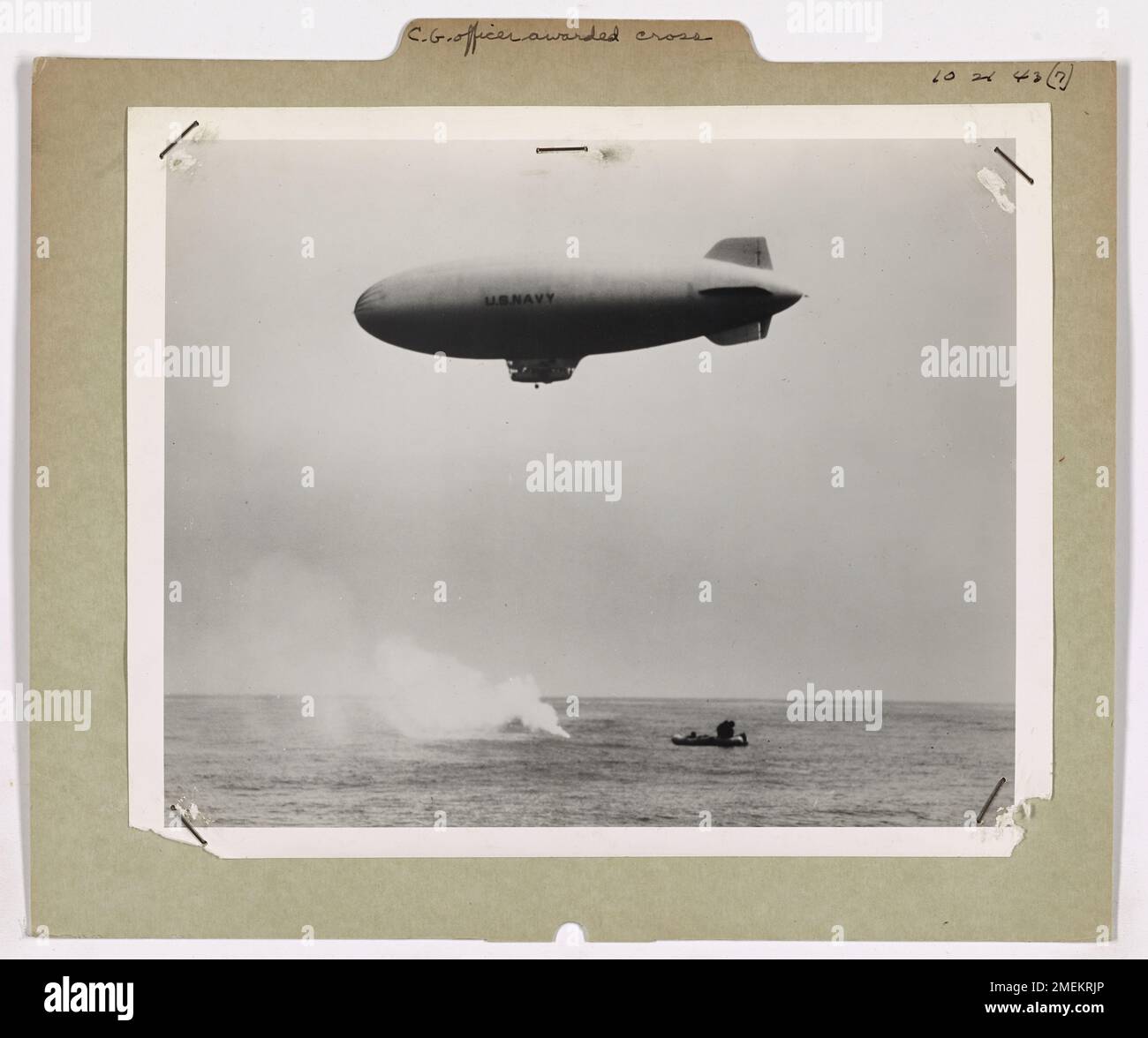 Sur cette image, le commandant Richard L. Burke de la Garde côtière américaine reçoit la Distinguished Flying Cross du secrétaire à la Marine Frank Knox pour ses sauvetages audacieux, y compris le sauvetage de sept survivants d'un U-boot allemand détruit. L'événement a eu lieu après une mission de sauvetage, avec un blimp de la Navy en tête marquant l'emplacement. Banque D'Images