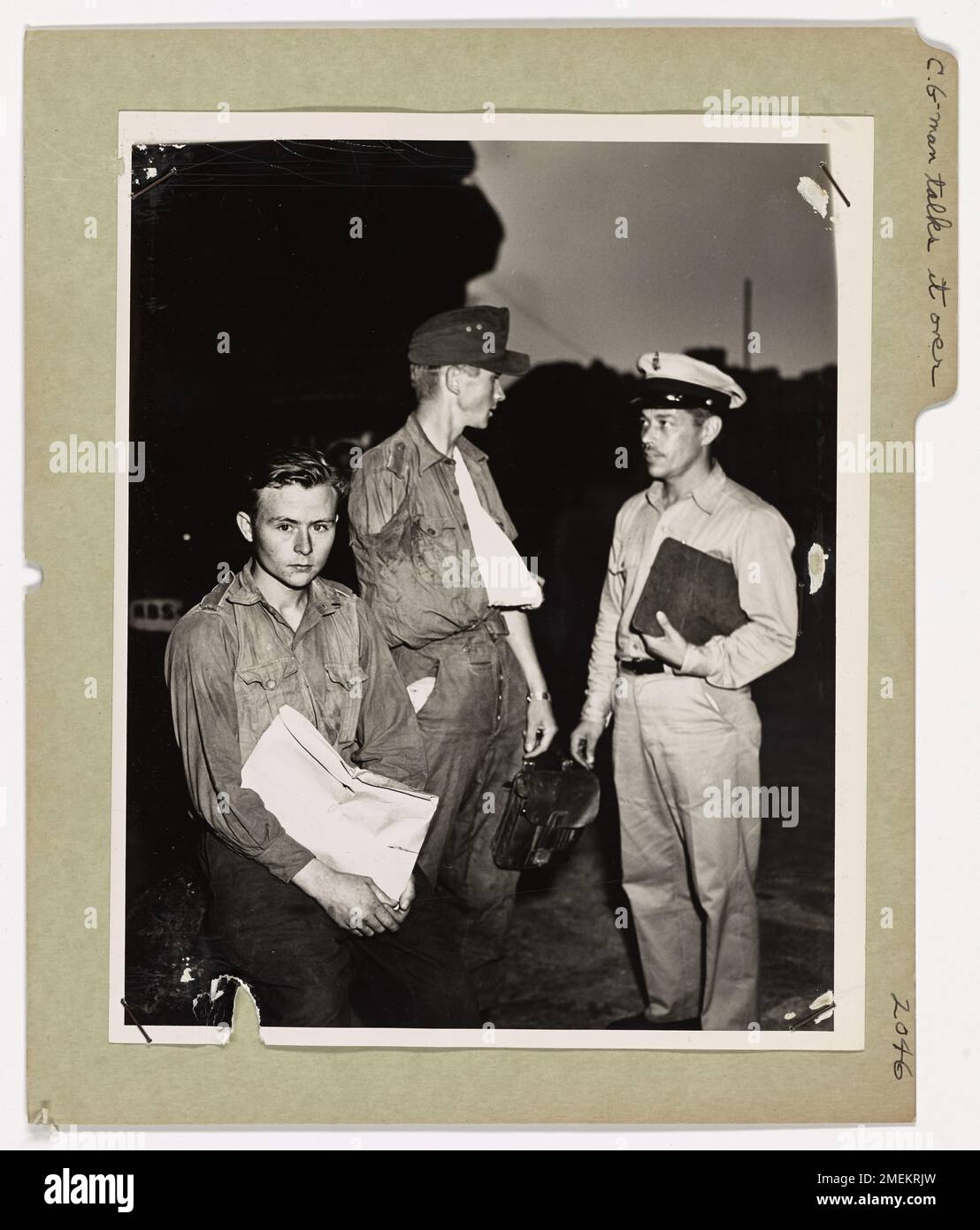 Coast Guardsman en parle avec les prisonniers. Quelque part en Méditerranée, Earl Sauter, gardien de la côte, parle à une paire de jeunes prisonniers allemands à bord d'un transport de garde côtière en route vers un port nord-africain. Les Allemands ont été capturés dans les combats autour de Salerne. Coast Guardsman Sauter est un compagnon de pharmacien en chef. Sa maison est au 1534A South Seventh Street, Milwaukee, Wisconsin. Banque D'Images