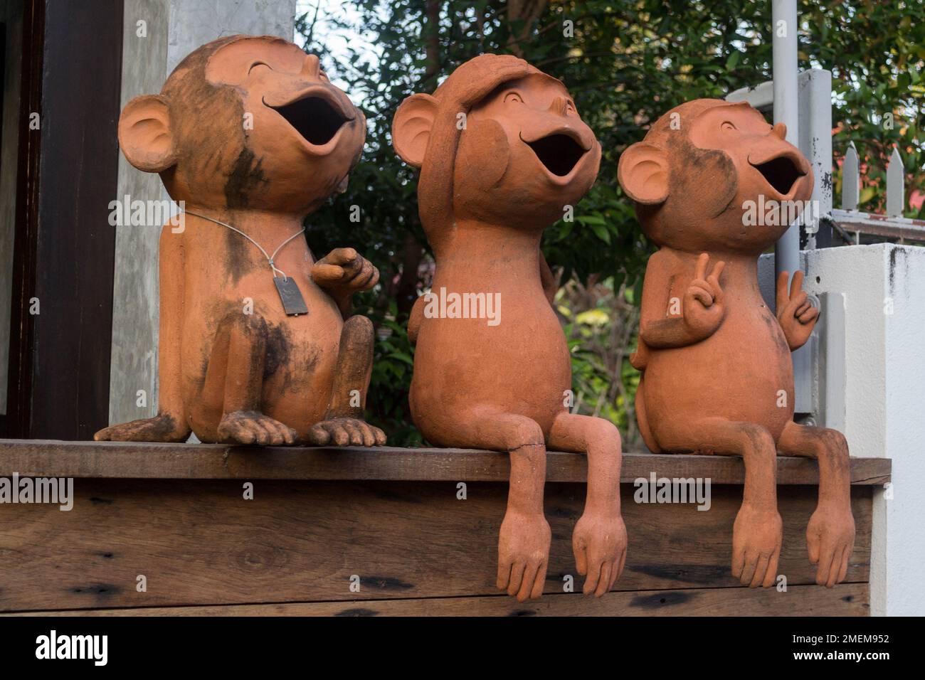 Trois jolies statues de singe en terre cuite avec bouches ouvertes. Banque D'Images