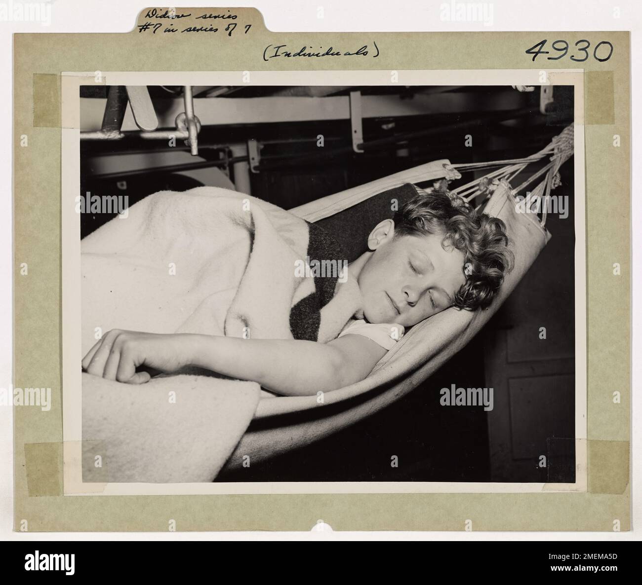 Eddie Didion, connu comme le « garçon mystère du front de mer allemand », retourne à son hamac à bord du coupe-côtes américain EAGLE après un départ à terre dans un club de la Croix-Rouge à Bremerhaven, en Allemagne. La série capture la vie d'Eddie à bord du navire pendant la seconde Guerre mondiale, avec la photo finale s'interrogeant sur son avenir après le départ du cutter. Banque D'Images