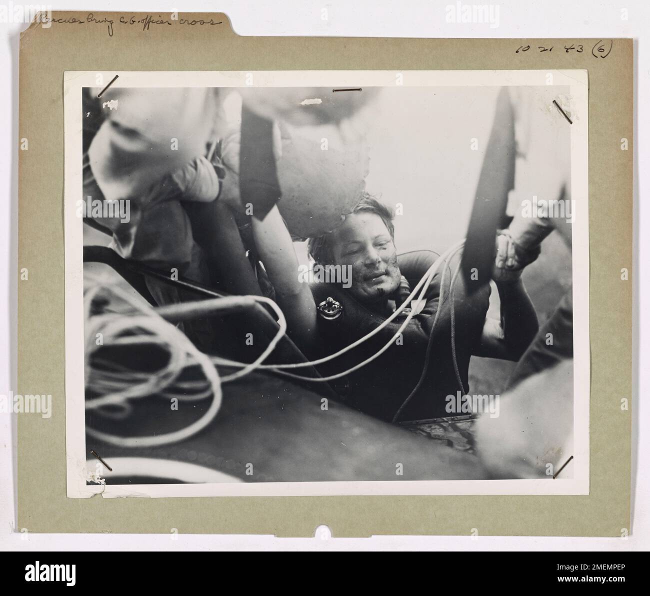 Le commandant Richard L. Burke de la Garde côtière américaine reçoit la Distinguished Flying Cross pour avoir sauvé un homme radio et six autres survivants d'un U-boot allemand. L'image montre le prisonnier allemand transporté à bord d'un avion de la Garde côtière après avoir été secouru, démontrant le rôle crucial de la Garde côtière dans les opérations de sauvetage air-mer. Banque D'Images