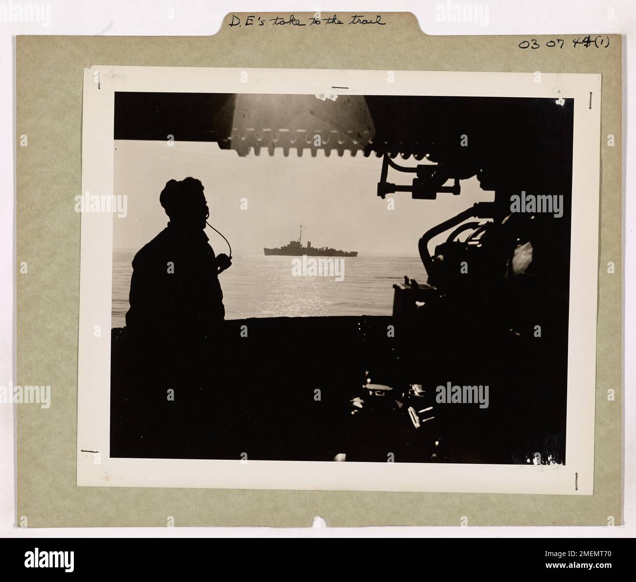 Un garde-côtes surveille un destroyer escorté, scannant les avions et les sous-marins ennemis. Cette image illustre le rôle des escortes de destroyers dans la protection des grands navires et le soutien des opérations navales pendant la seconde Guerre mondiale Banque D'Images