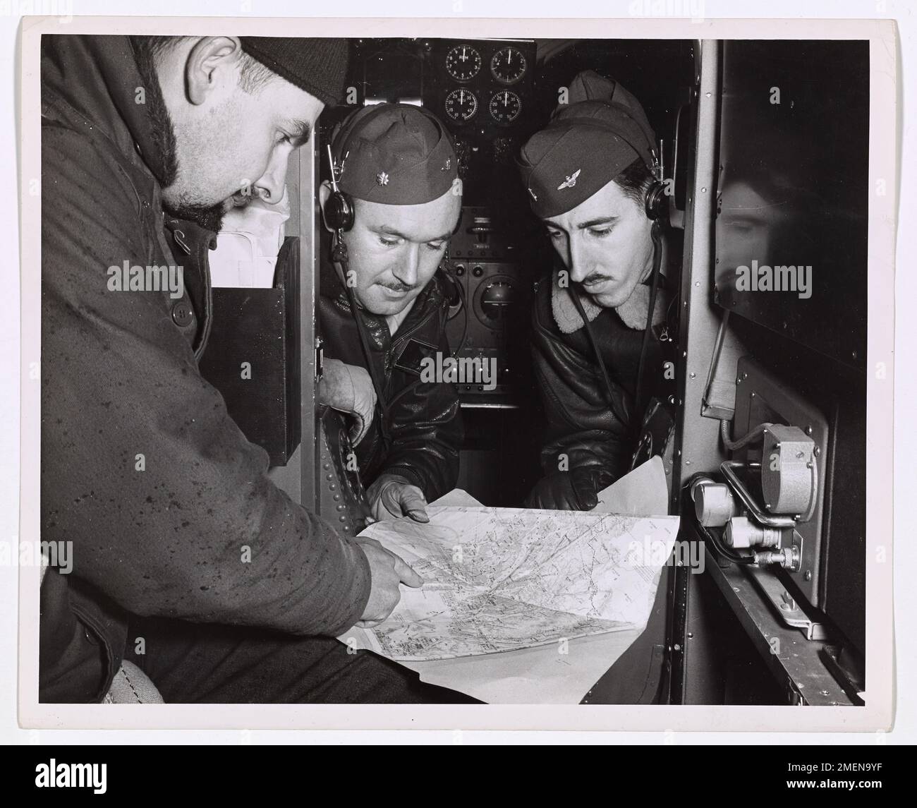 Les para-sauveteurs de la Garde côtière mènent une mission de sauvetage dans la nature sauvage de l'Alaska. Le parachutiste Bruce Johnstone montre le site de l'accident au lieutenant Comdr. Joseph McCue et l'enseigne James Gwynn. L'équipe est prête à faire du parachute et à secourir les victimes de l'accident. Banque D'Images