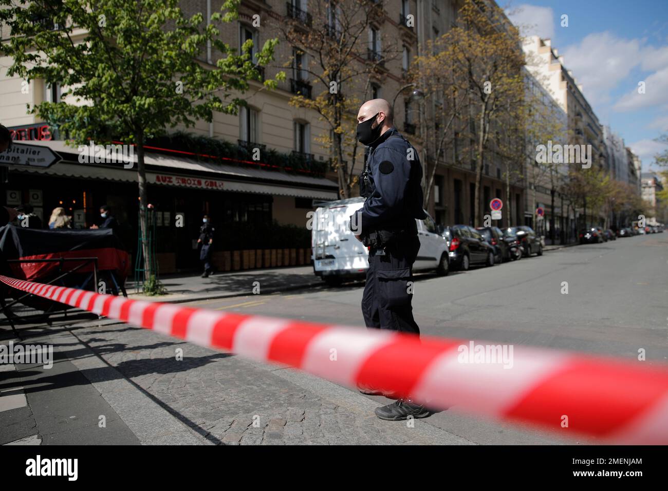 A police officer stand behind the police limit after a shooting Monday, April 12, 2021 in Paris. Paris police are hunting for a gunman who opened fire on Monday near a hospital in the tony 16th district of the French capital, killing one person and injuring another. Paris police said the shooter fired several shots before fleeing on a two-wheeled vehicle(AP Photo/Christophe Ena) Banque D'Images