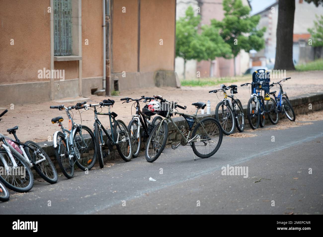 France, Bourgogne, Saône-et-Loire, Cluny, vélos garés contre le mur bas Banque D'Images