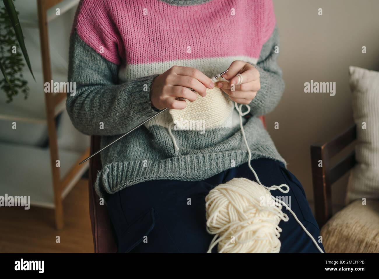 Gros plan sur les mains d'une femme douillette femme en tricot chaud tricoté aime le travail en tricot sur une chaise à la maison en hiver confortable. Nouveau petit Banque D'Images