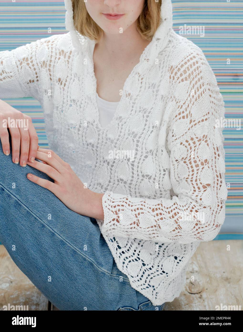 Jeune femme portant un pull à capuche blanc tricoté en dentelle Banque D'Images