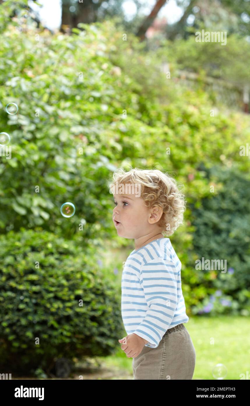 Petit garçon soufflant une bulle, 2 ans 4 mois Banque D'Images