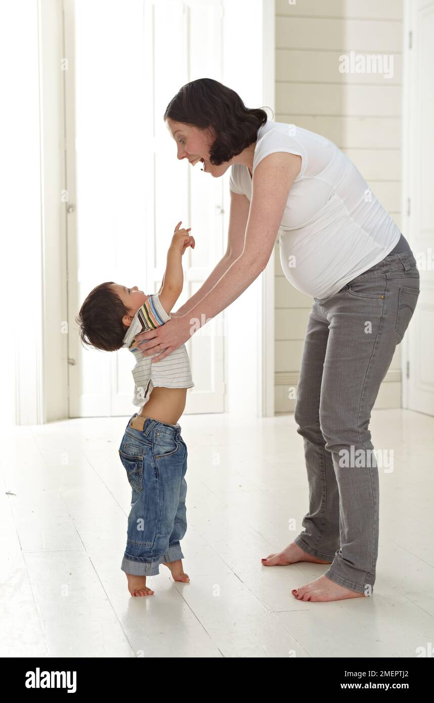 Femme enceinte debout tenant les mains avec un petit garçon Banque D'Images