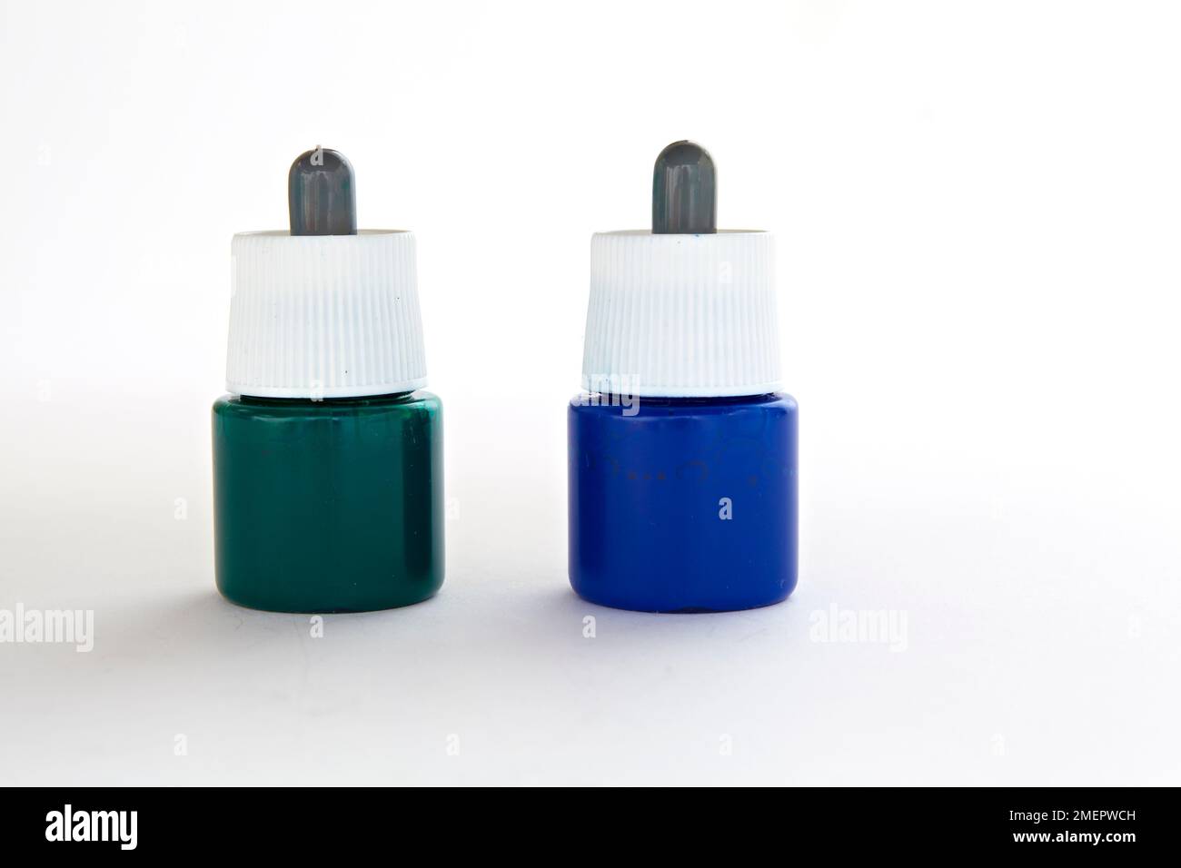 Deux petits pots de pipettes de colorants marbrures verts et bleus, gros plan Banque D'Images