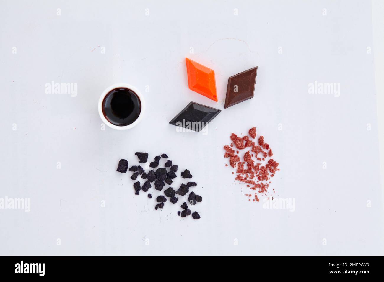 Colorant liquide dans un petit bol, des flocons et des photos en forme de losange concentré, vue de dessus Banque D'Images