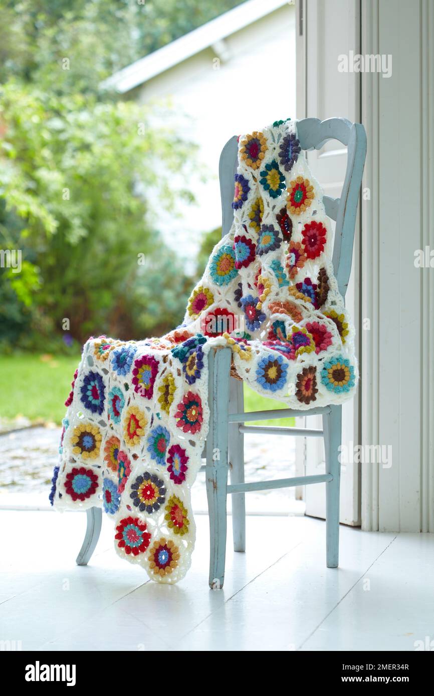 Couverture en crochet colorée à motif fleuri drapée au-dessus d'une chaise  Photo Stock - Alamy
