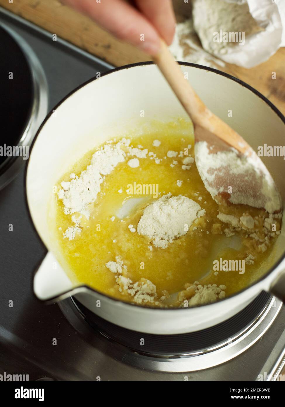 Mélanger le beurre fondu avec la farine (la cuisson béchamel) Banque D'Images