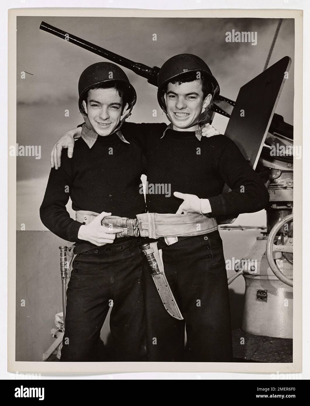 Des Twins Bostonese dans un transport de l'Atlantique. Ils sont âgés de 17 ans, ces jumeaux de la Garde côtière de Dorchester, Massachusetts, et ils se ressemblent autant que ces personnages célèbres, « Ike et Mike ». En fait, l'un des frères Collins s'appelle Mike, mais son frère est John. Mike est celui de gauche ou peut-être celui de droite. Quelle différence cela fait-il ? Les jumeaux de Collins se sont rassemblés à Boston sur 17 novembre 1944, à l'âge de 17 ans. Ils servent maintenant sur un transport de troupes de la Garde côtière qui transporte des renforts de l'autre côté de l'Atlantique. Il semble qu'une ceinture de vie suffise pour les deux. TH Banque D'Images