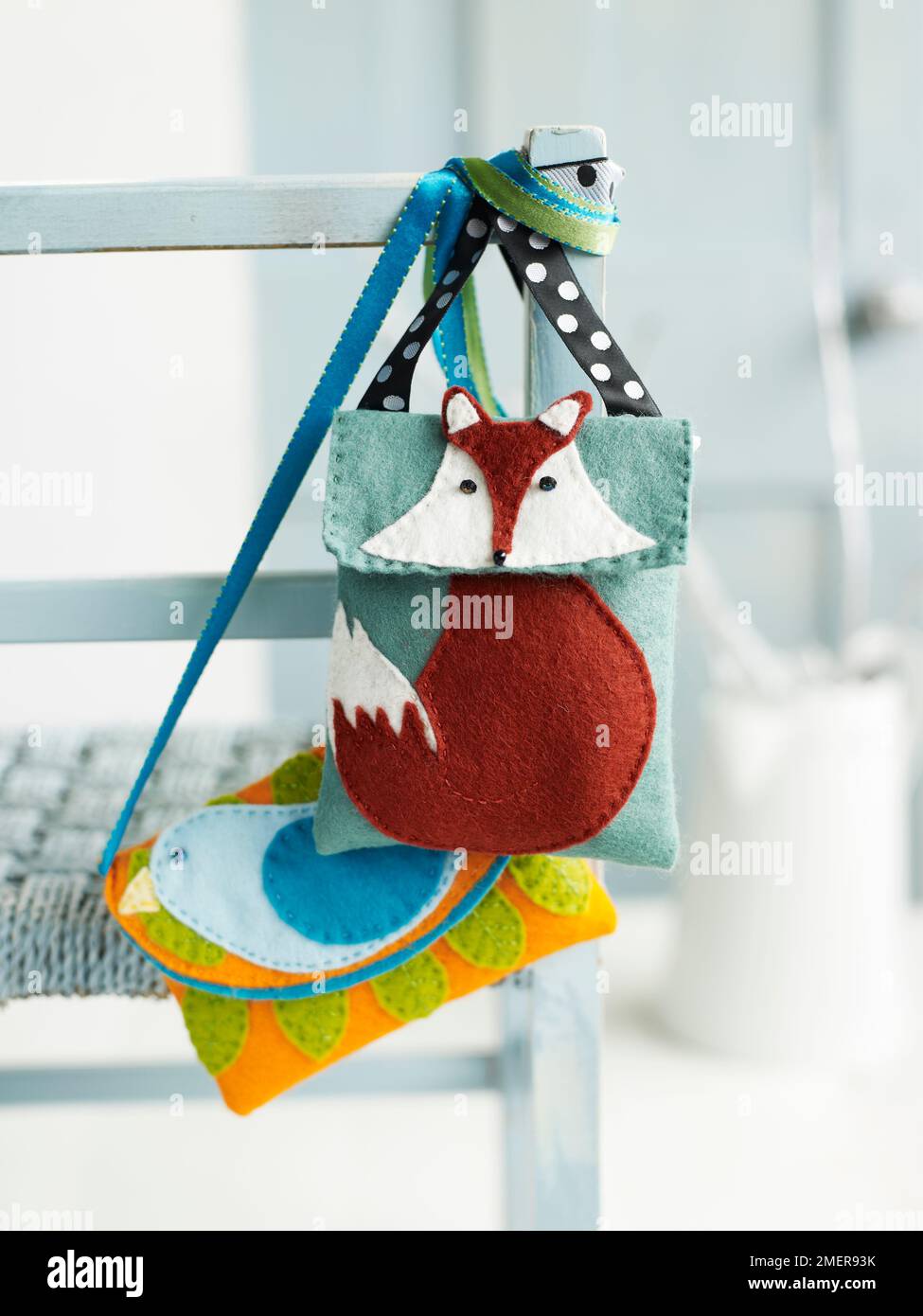 Sacs à motif renard en feutre et oiseau en feutre suspendus sur une chaise Banque D'Images