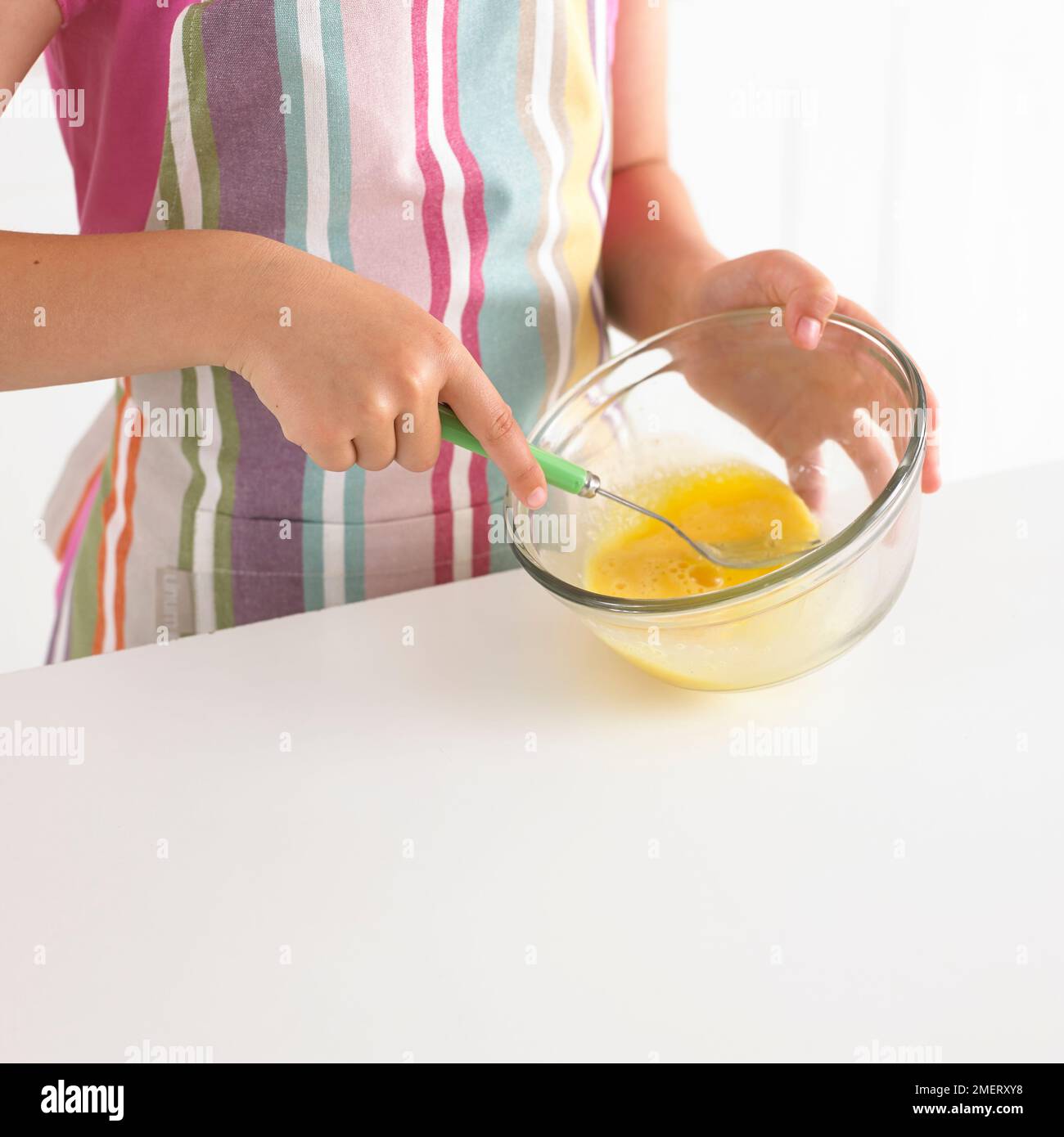 Battre les œufs dans un bol, 8 ans Banque D'Images