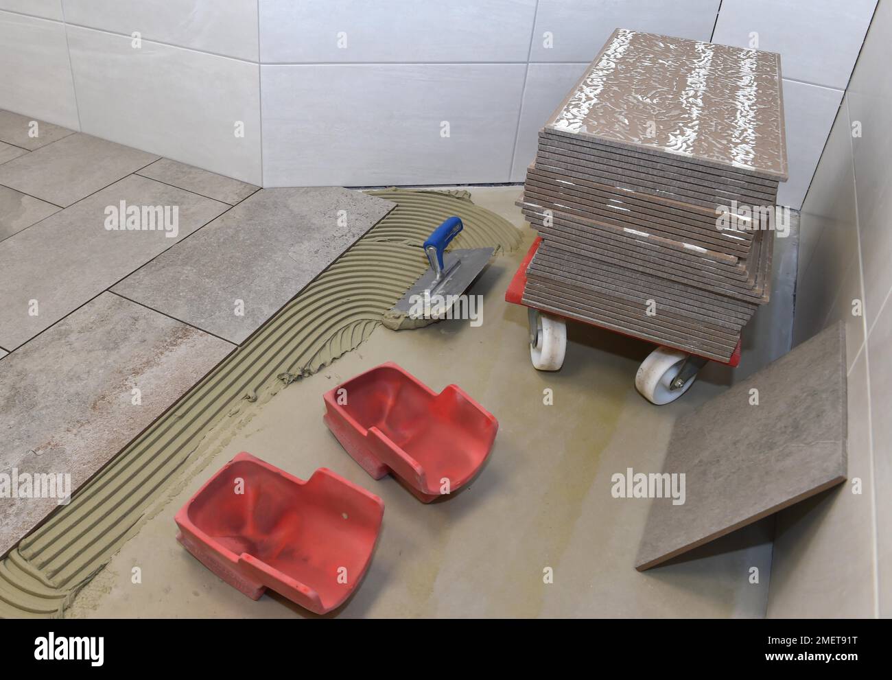 Tiler a appliqué l'adhésif pour carreaux et colle sur les nouveaux carreaux, Hesse, Allemagne Banque D'Images