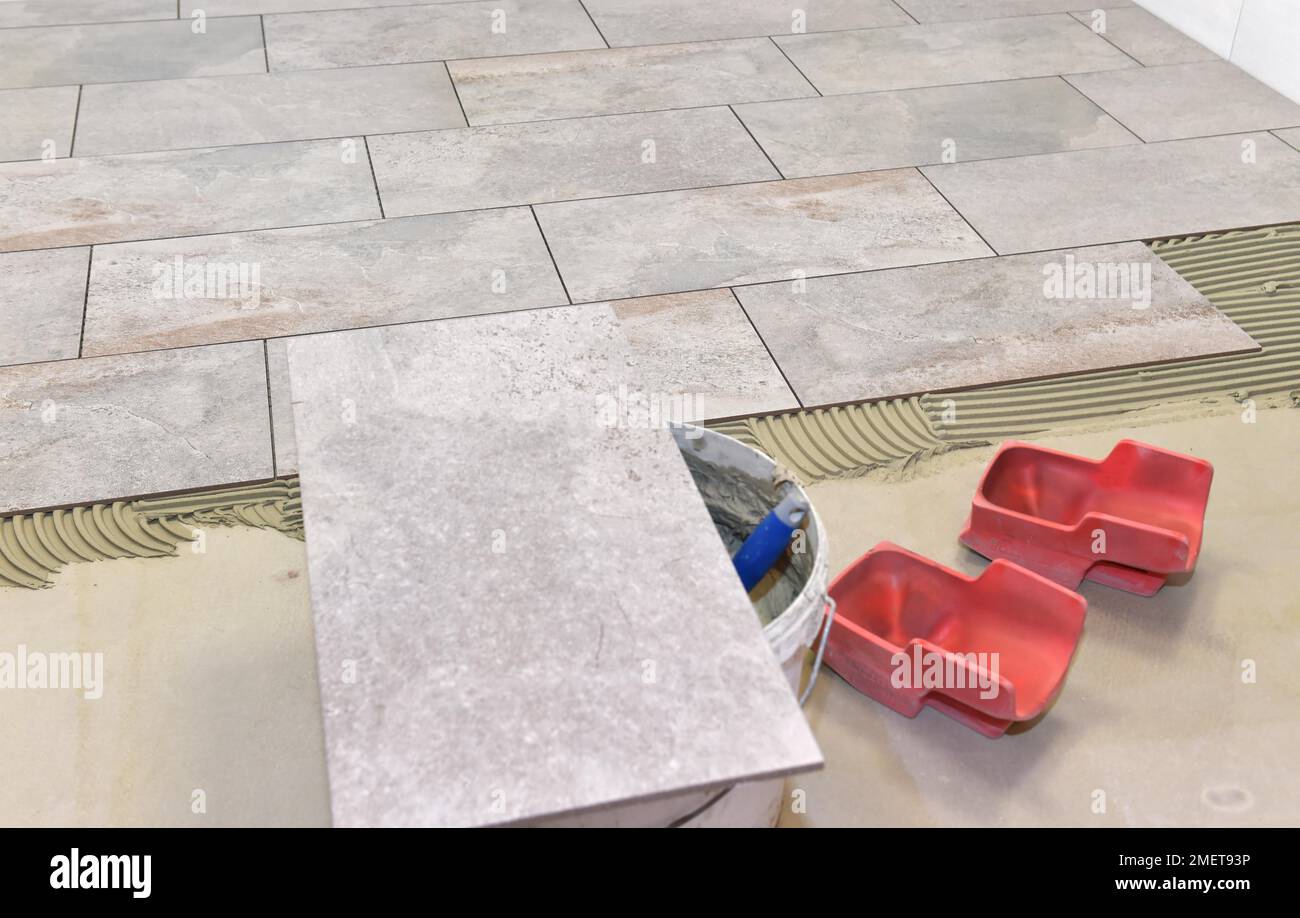 Tiler a appliqué l'adhésif pour carreaux et colle sur les nouveaux carreaux, Hesse, Allemagne Banque D'Images