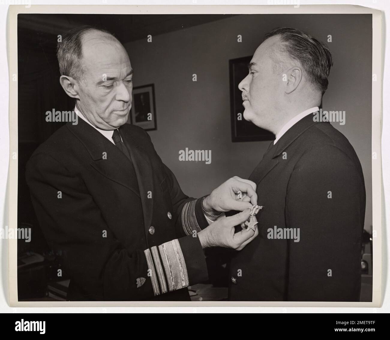 Le lieutenant-commandant James S. Hunt, de la Garde côtière américaine, est décoré par le vice-amiral R. R. Waesche de l'étoile d'argent pour sa bravoure manœuvrant des bateaux d'assaut à Salerne. Précédemment décoré par le roi George V en 1918, le service de Hunt illustre l'héroïsme dans les deux guerres mondiales. Banque D'Images